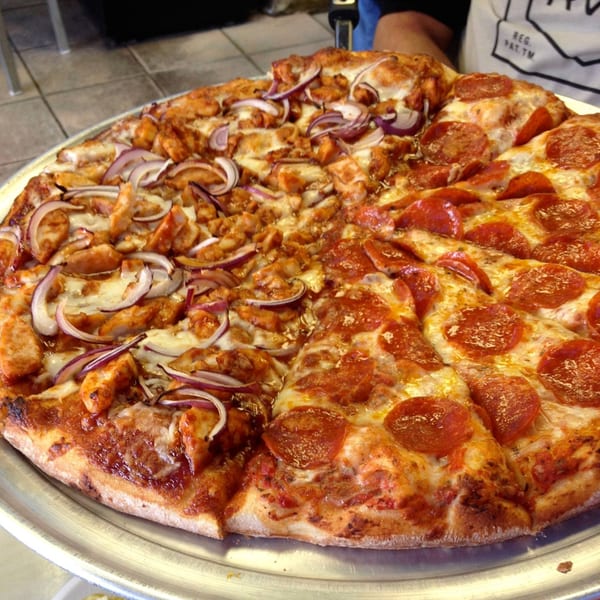 A large Jack's Pizza with half pepperoni and half BBQ chicken with red onions.